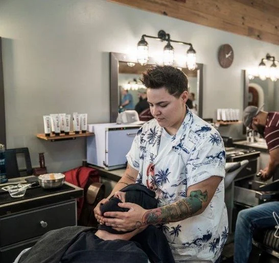 A student applies a hot towel treatment.